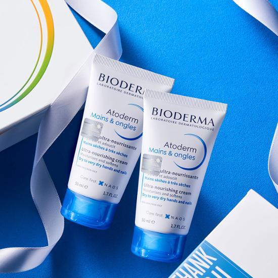 Two tubes of Bioderma Atoderm Hand & Nail Cream, designed for moisturizing and nourishing hands and nails, featured in a body care product set.