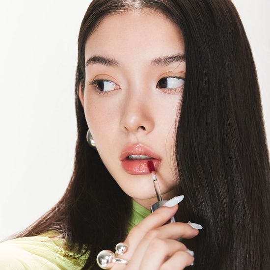 Seven vibrant shades of Dewy Glass Lip Tint by ABIDE displayed in elegant tubes.