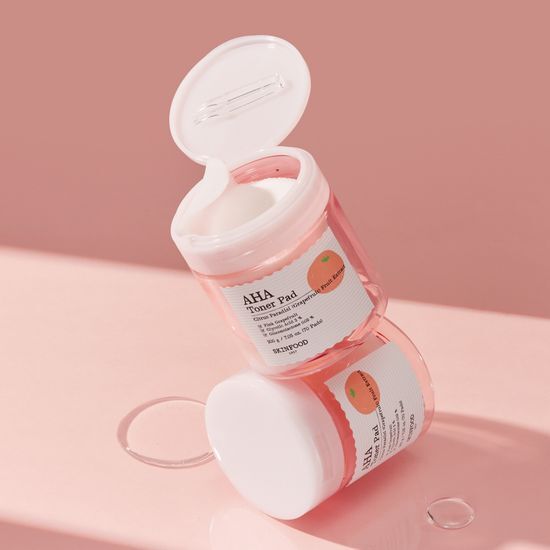 Skinfood Pink Grapefruit AHA Toner Pads - 70 sheets, a skincare product designed for exfoliation and brightening, featuring vibrant pink packaging.